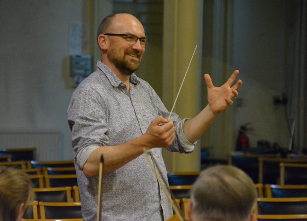 Jonathan Abbott conducting SBMS during rehearsal.